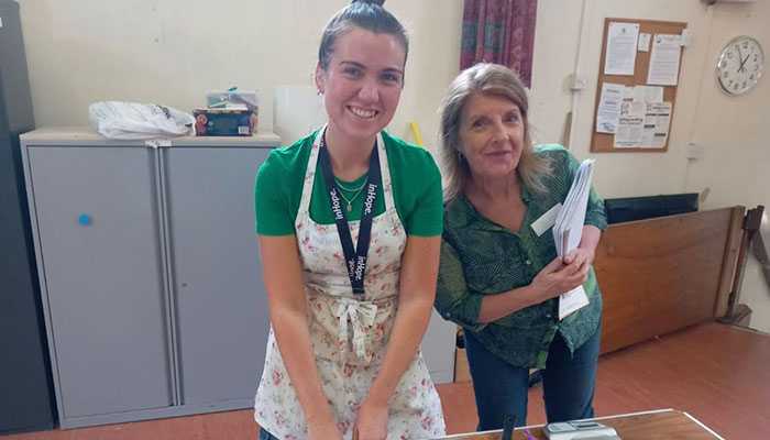Two women standing next to each other in a kitchen.