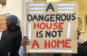 Barton House: some residents’ belongings being removed by the Council a person holding a sign