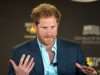 Prince Harry speaking with his hands up in motion.