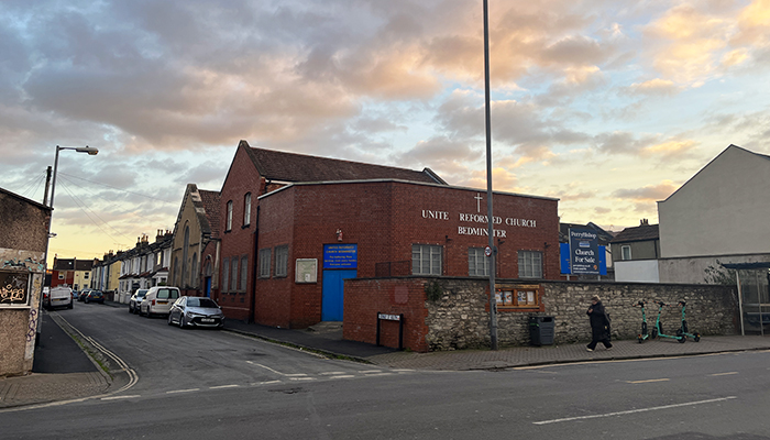 A brick building with blue doors. This is the URC on West Street, Bedminster, Bristol.